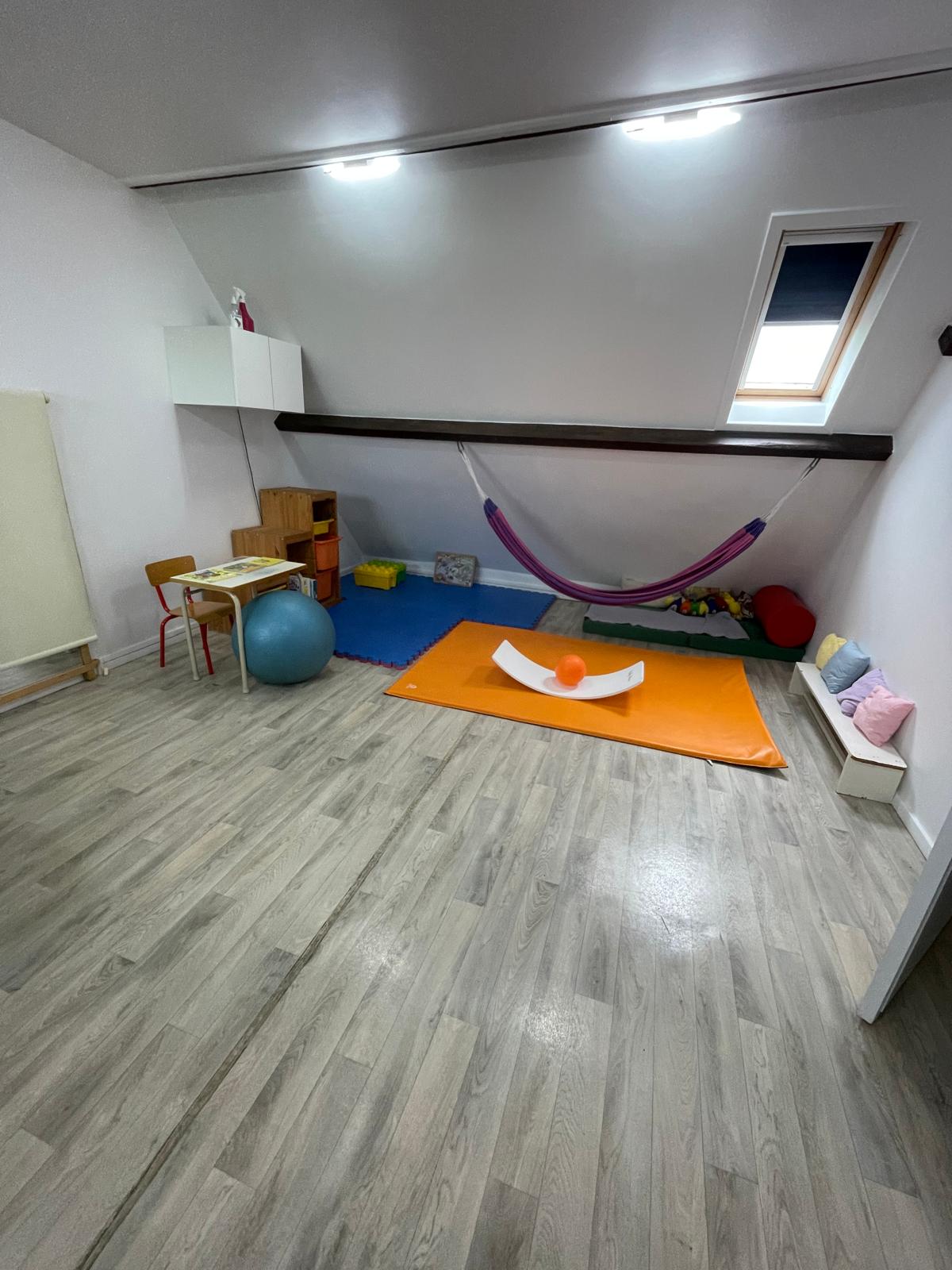 La salle de motricité, avec tapis, espalier et matériel de parcours